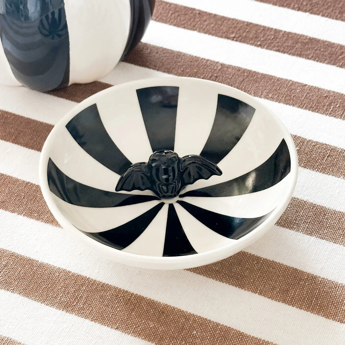 Piattino biscotti Onyx in ceramica a righe bianco e nero con statuetta pipistrello al centro