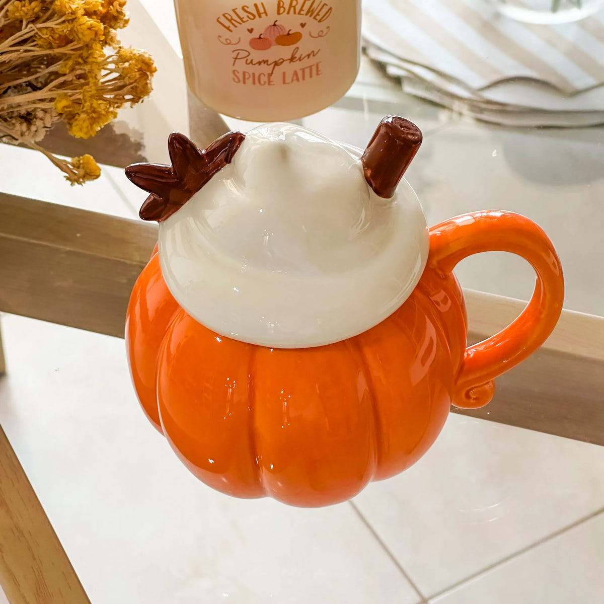 Tazza Zuccosa in ceramica smaltata arancione a forma di zucca con manico arricciato e coperchio che simula la panna montata con fiori di anice in rilievo