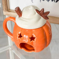 Brucia essenze in ceramica smaltata arancione a forma di zucca con coperchio che simula la panna montata con stecca di cannella e fiore di anice stellato in ceramica