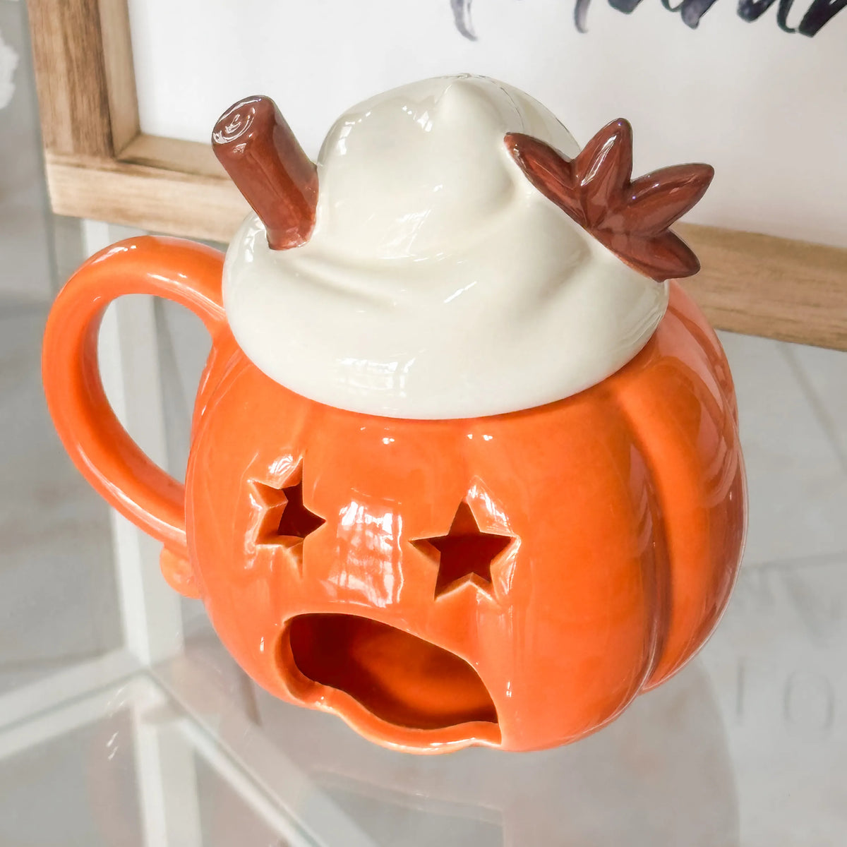 Brucia essenze in ceramica smaltata arancione a forma di zucca con coperchio che simula la panna montata con stecca di cannella e fiore di anice stellato in ceramica