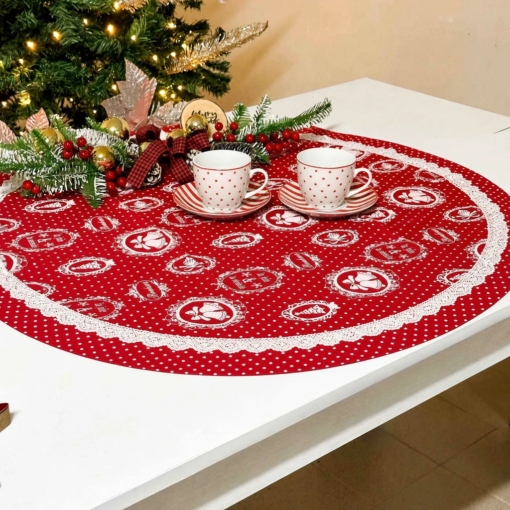 Centrotavola tondo in cotone rosso con pois bianchi, stemmi decorativi e merletto bianco su una tavola natalizia